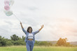 © sunti - Happy beautiful young woman standing holding colorful of balloon