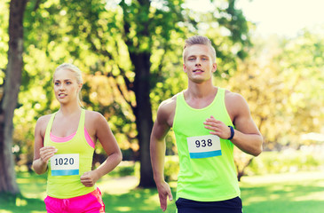 Canvas Print - happy sportsmen couple racing wit badge numbers