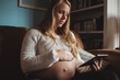 © Wavebreak Media - Pregnant woman using digital tablet in living room