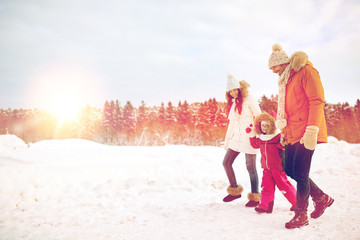 Wall Mural - happy family in winter clothes walking outdoors