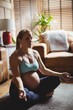 © Wavebreak Media - Pregnant woman performing yoga in living room