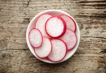 Wall Mural - Bowl of radish slices, from above