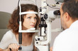 © Stocked House Studio - Optometrist in exam room with woman in chair