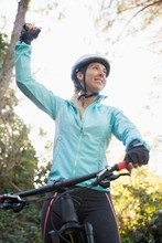 Excited Female Mountain Biker In Forest