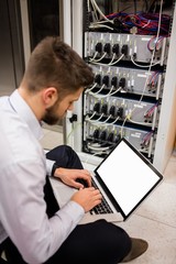 Fototapete - Technician using laptop while analyzing server