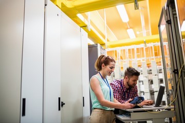 Fototapete - Technicians using laptop while analyzing server