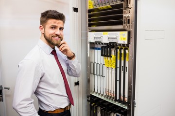 Fototapete - Technician talking on mobile phone in server room