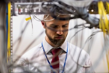Fototapete - Technician checking cables in a rack mounted server