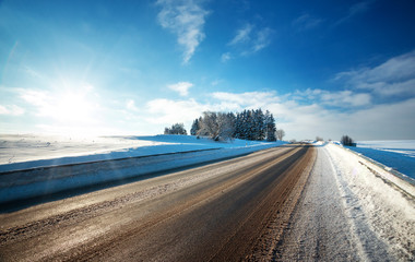 Asphalt road in snowy winter on beautiful frosty sunny day