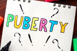 Puberty written on notepad on a table.