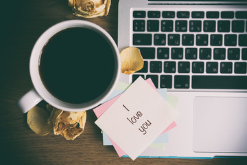 A cup of coffee, a note near the cup, the cup on a white backgro