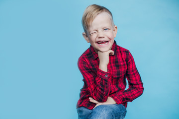 Wall Mural - Fashionable little kid with red shirt. Fashion. Style. Studio portrait over blue background