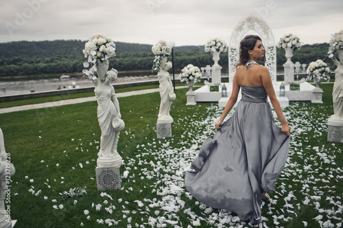 The adorable bridesmaid stands near archway Poster