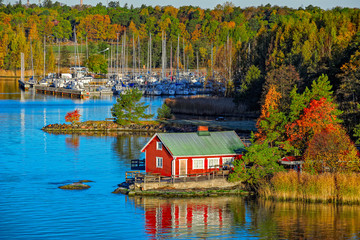 red house on rocky shore of ruissalo island, finland