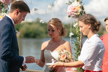 Groom is giving a ring to the bride on the wedding ceremony