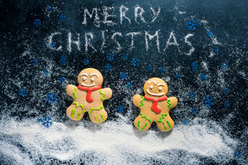 Baking Gingerbread Men for Christmas on dark table