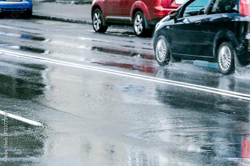Fotografía cars driving on wet asphalt road after heavy rain