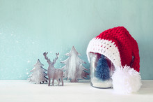 Cute Knitted Santa Hat On Mason Jar With Christmas Tree