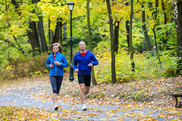 Wall Mural - Woman and man running in park