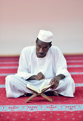 Wall Mural - African Muslim Man Making Traditional Prayer To God While Wearing A Traditional Cap Dishdash