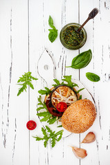 Fresh homemade two veggies burgers over white rustic table. Vegan grilled eggplant, arugula, sprouts and pesto sauce burger. Veggie beet and quinoa burger. Top view, overhead, flat lay