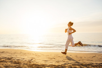 Wall Mural - Caucasian woman jogging at seashore