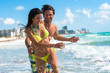 Attractive young couple man and woman playing in surf at South Miami Beach Florida with hotels in background