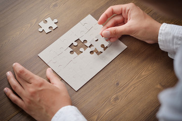 Wall Mural - Image of businesswoman connecting elements of white puzzle