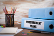 © STOATPHOTO - Procurement Plans, Office Binder on Wooden Desk. On the table co
