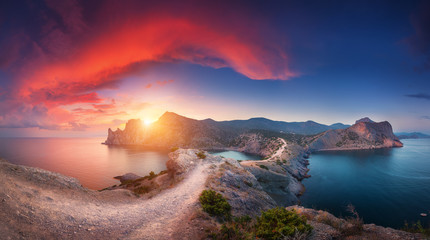 Wall Mural - Amazing summer landscape with mountains, sea, blue sky, sun and beautiful colorful red clouds at sunset in Crimea. Sunset in mountains. Panoramic. Nature background. Vibrant landscape in twilight. 