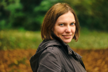 Beautiful smiling young adult woman in autumn park