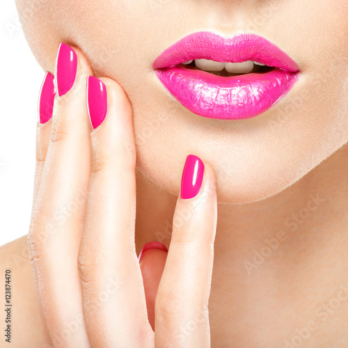 Fotografia, Obraz Closeup woman hand with pink nails near lips.
