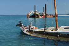 Sunk Ruined Wooden Boat And Old Rusty Dredger In Calm Blue Bay