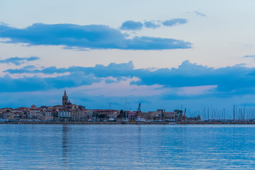 Wall Mural - Alghero under a blue sky at sunset