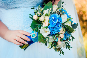 Luxury bridal bouquet in blue and beige colors with a brooch