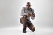 © Jacob Lund - Fit young african man kneeling on grey background