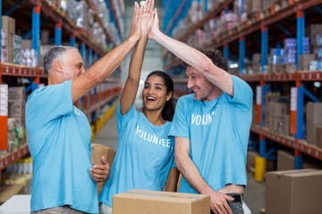 Three excited volunteers giving high five