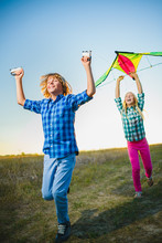 Group Of Happy And Smiling Kids Playingin With Kite Outdoor
