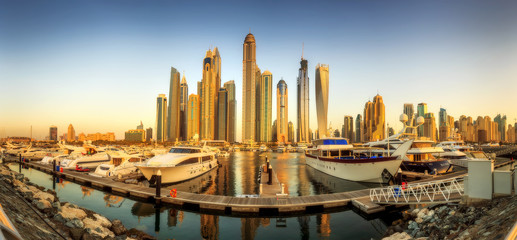 Panoramic view of Dubai Marina bay with yacht and cloudy sky, Dubai, UAE.