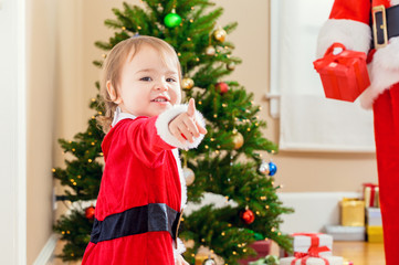 Happy toddler girl interacting with Santa Claus