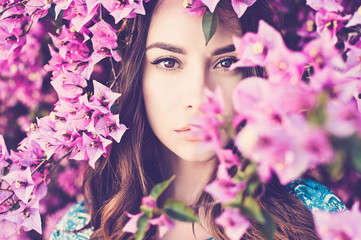 Beautiful young woman surrounded by flowers