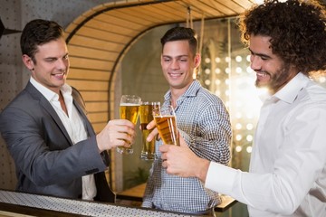 Wall Mural - Group of friends toasting a glass of beer