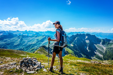 Wall Mural - Happy young woman in hiking gear looking back