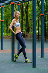 Wall Mural - Young slim woman sports portrait on the training ground in a park