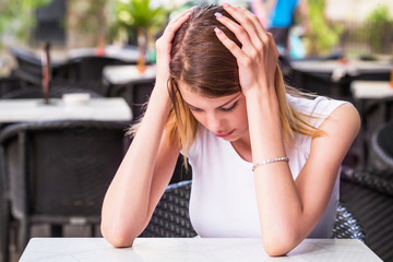 Wall Mural - sad teenage woman sitting , she is touching head