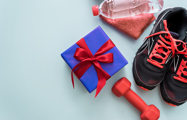 fitness equipment and gift on blue background