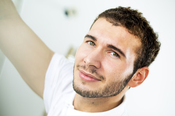  Young handsome man. 
Pretty young guy looking throw window. Close up. Profile.