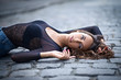 portrait of beautiful brunette young woman lying on the road