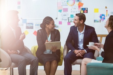 Wall Mural - Businesswoman discussing with colleagues over digital tablet