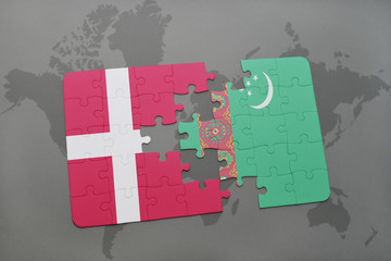 puzzle with the national flag of denmark and turkmenistan on a world map background.